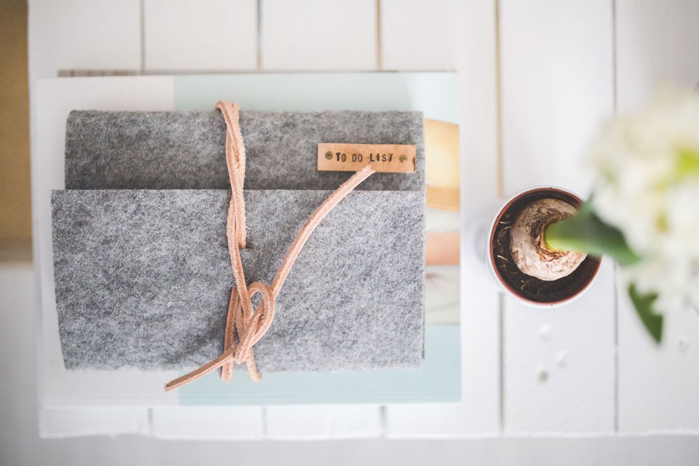 fotografía en picado de una mesa de madera con un cactus y una libreta de color gris